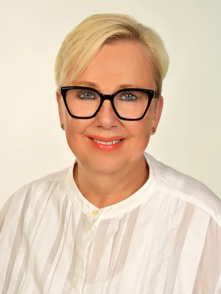 Porträt von Susanne Wagner, Ärztin, Paartherapeutin und Psychoonkologin, mit kurzem blonden Haar und schwarzer Brille.